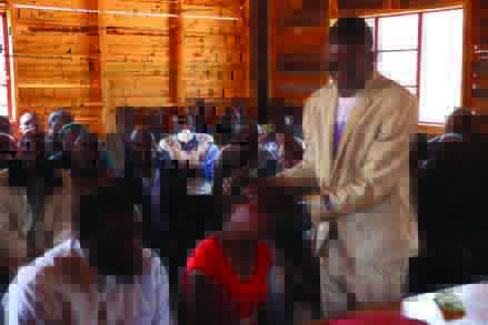 An unidentified prophet prays for Rumbidzai Ngomana during the court session